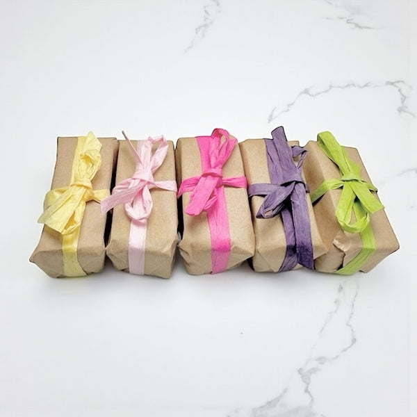 Selection of mini natural honey soaps in assorted scents gentle cleansing bars ideal for sensitive or menopausal skin, beautifully wrapped for gifting.